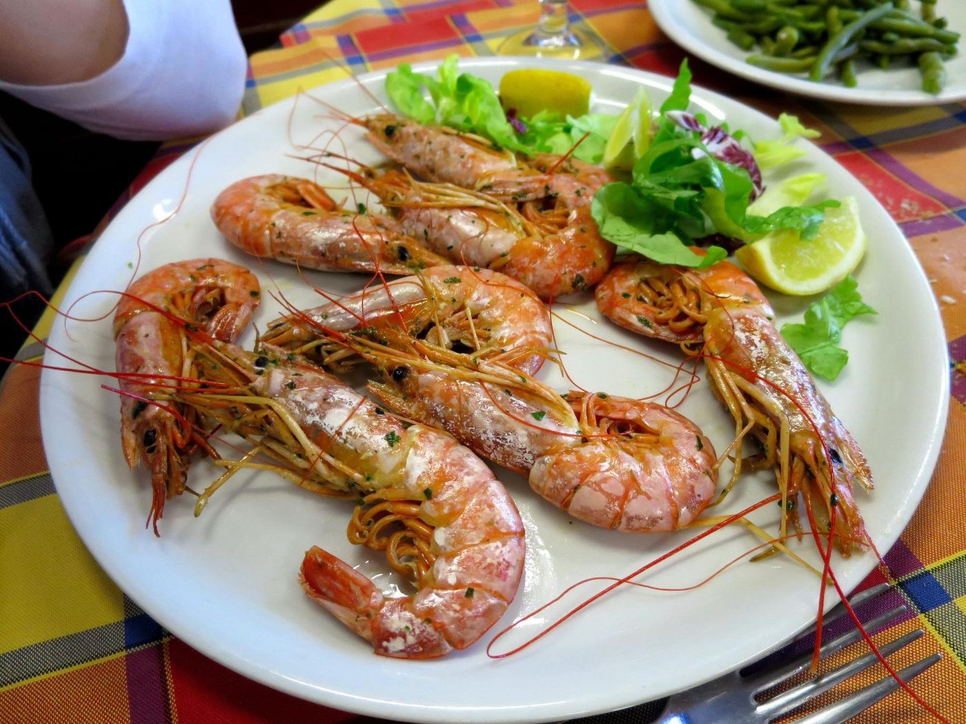 Piatto di gamberoni alla griglia con insalata e limone