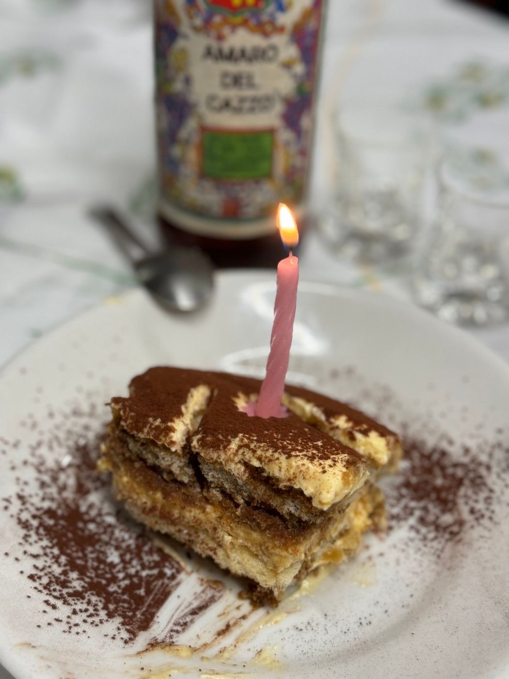 Fetta di tiramisù con una candelina accesa